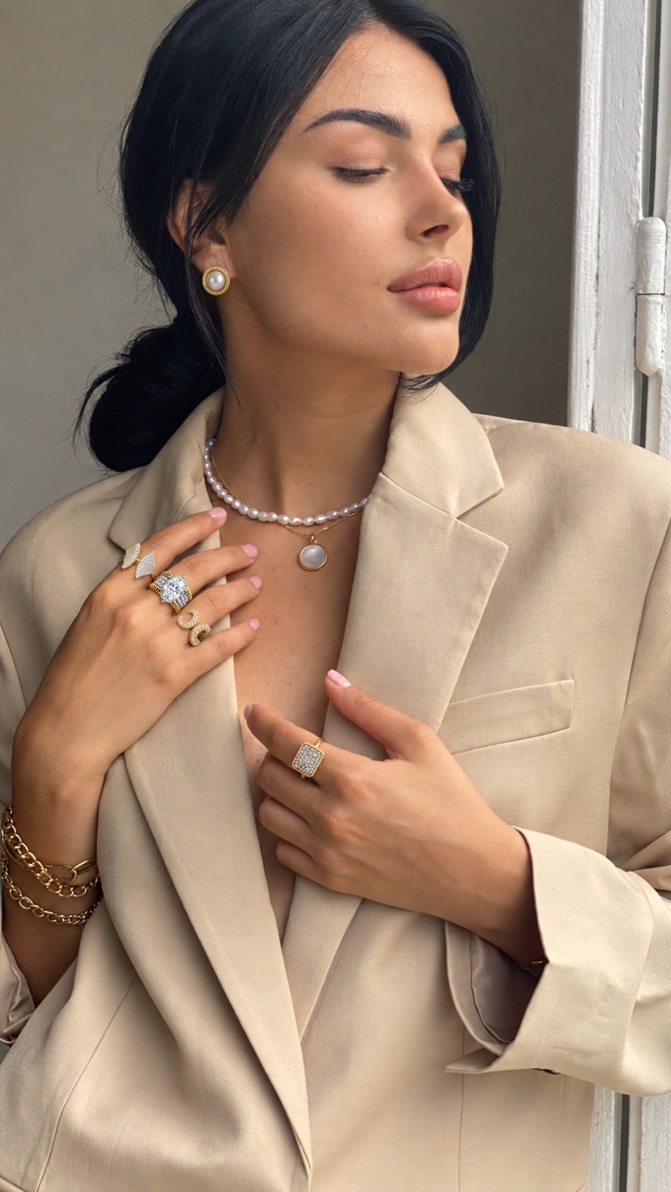 Pearl and gold jewelry with a neutral tailored blazer