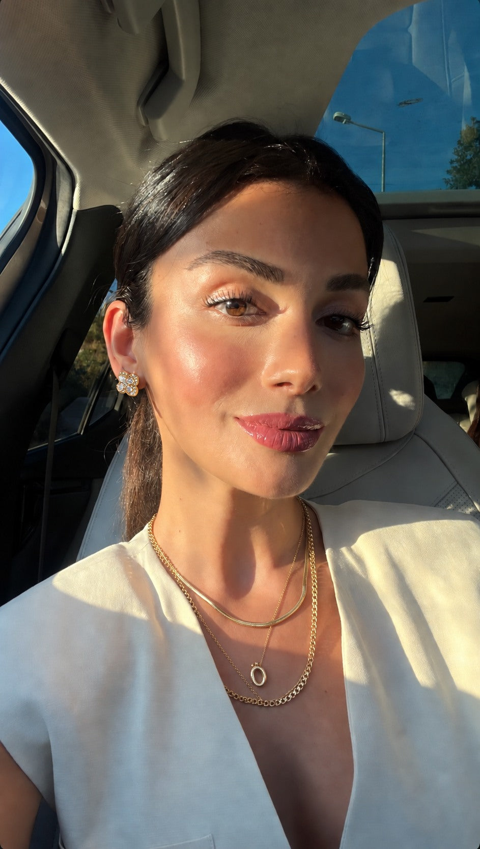 Gold earrings and layered necklaces in warm light